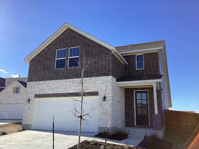 traditional-style home featuring stone siding, driveway, a garage, and fence