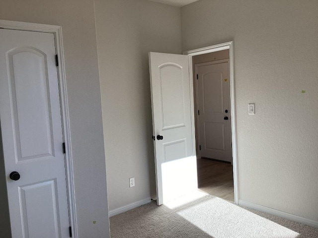 unfurnished bedroom with light colored carpet and baseboards