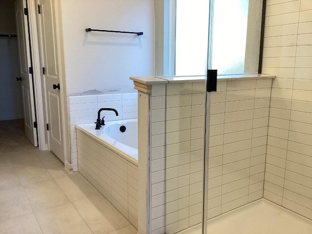 full bathroom with tile patterned floors, a tile shower, and a garden tub