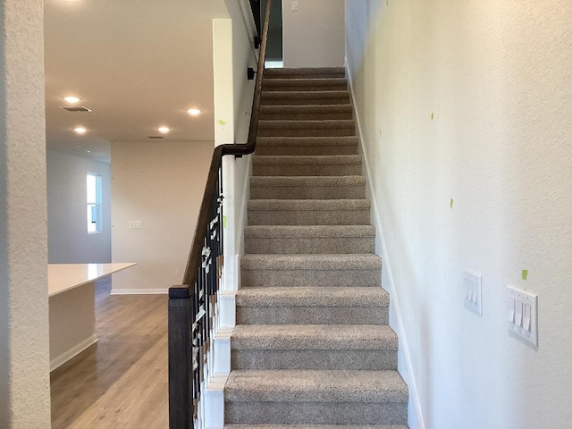 staircase with visible vents, recessed lighting, baseboards, and wood finished floors