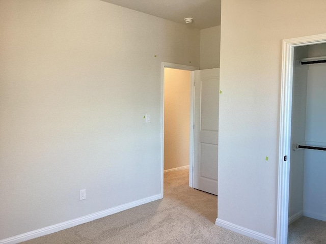 unfurnished bedroom with a closet, carpet flooring, and baseboards