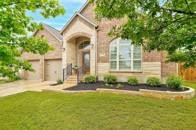 view of front of house featuring a front lawn, a garage, brick siding, and driveway