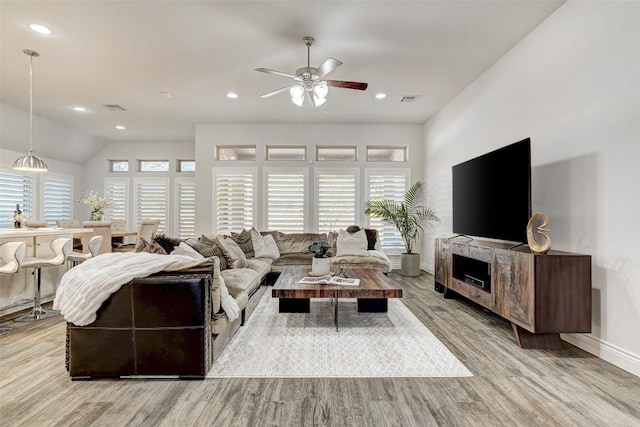 living area with visible vents, a ceiling fan, light wood-style floors, and a wealth of natural light