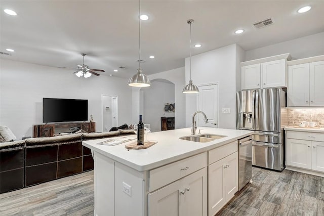 kitchen featuring a ceiling fan, visible vents, a sink, appliances with stainless steel finishes, and tasteful backsplash