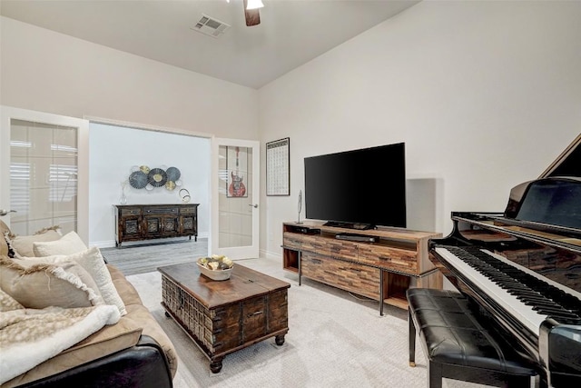 living room with a ceiling fan, visible vents, and baseboards