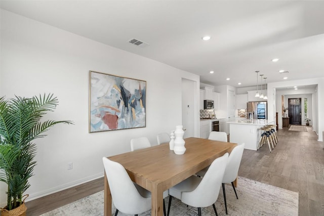 dining area featuring light wood finished floors, visible vents, recessed lighting, and baseboards