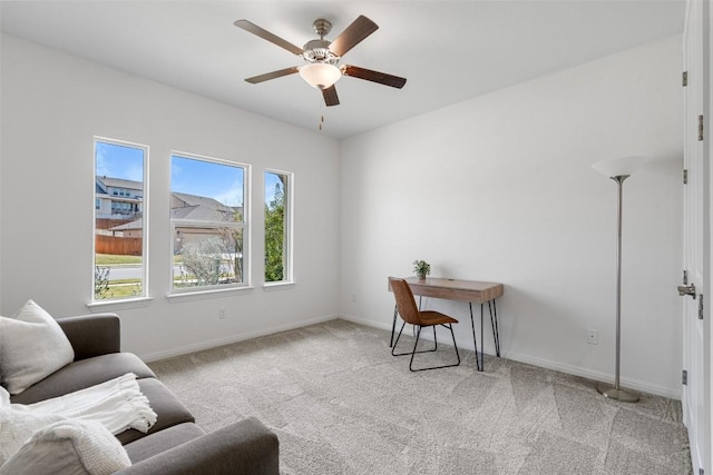 carpeted home office featuring baseboards and a ceiling fan