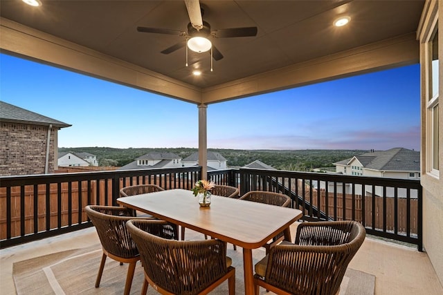 deck at dusk featuring outdoor dining space and a ceiling fan