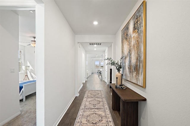 corridor with visible vents, baseboards, and wood finished floors