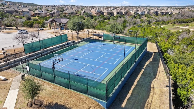 view of sport court with fence and a residential view