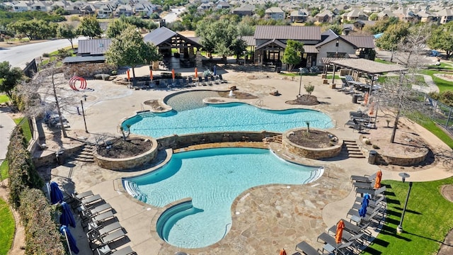 community pool featuring a jacuzzi, a residential view, fence, and a patio area