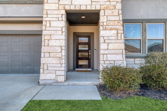 entrance to property with a garage and stone siding