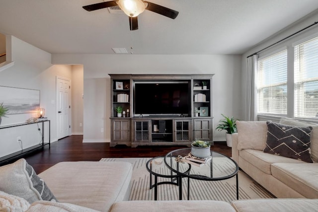 living room with visible vents, wood finished floors, baseboards, and ceiling fan