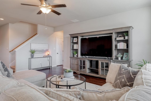 living room featuring baseboards, wood finished floors, visible vents, and ceiling fan