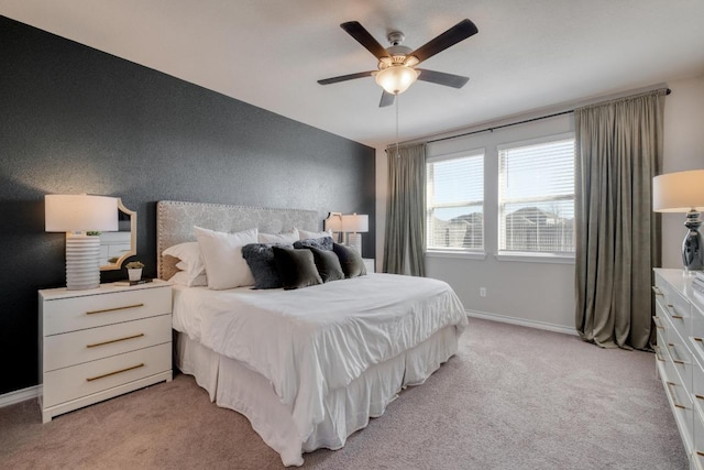 bedroom with light colored carpet, baseboards, and ceiling fan