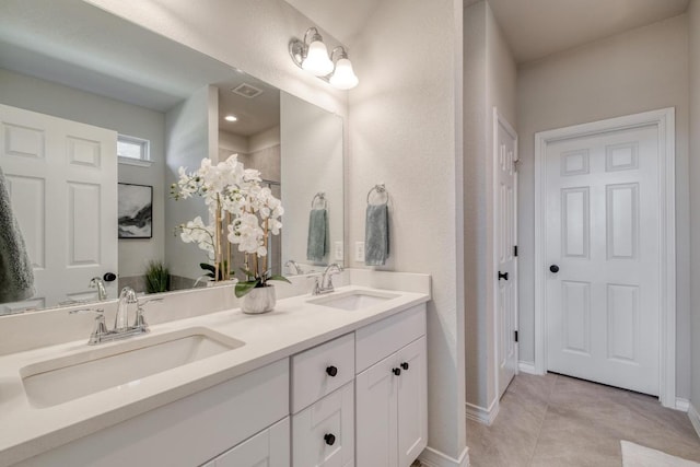 bathroom featuring tile patterned floors, double vanity, visible vents, and a sink