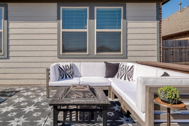 view of patio with an outdoor living space with a fire pit and fence