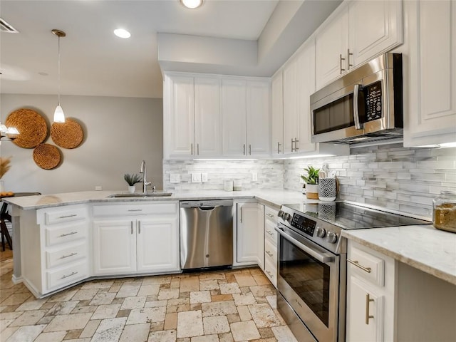 kitchen with white cabinetry, a peninsula, appliances with stainless steel finishes, and a sink