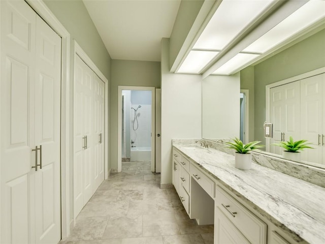 bathroom with tub / shower combination, baseboards, and vanity