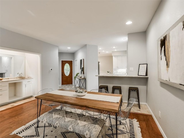 dining space with light wood finished floors, recessed lighting, and baseboards