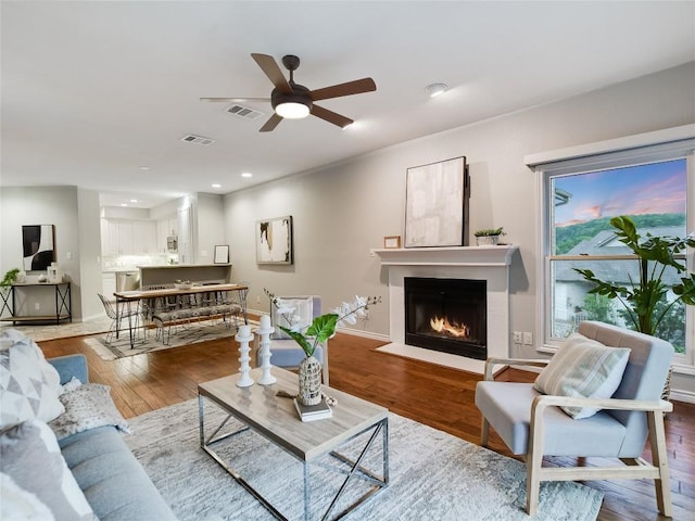 5603 Oakwood Cv Unit 232, Austin, TX 78731 - living area featuring ceiling fan, a fireplace with flush hearth, wood finished floors, and recessed lighting