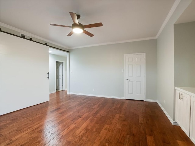 empty room featuring dark wood finished floors, baseboards, crown molding, and ceiling fan