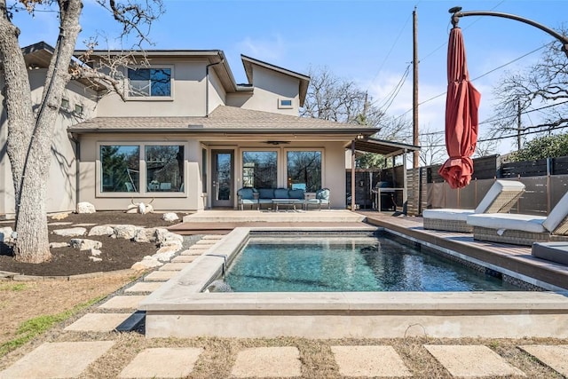 rear view of property featuring stucco siding, a patio, a fenced backyard, outdoor lounge area, and a fenced in pool