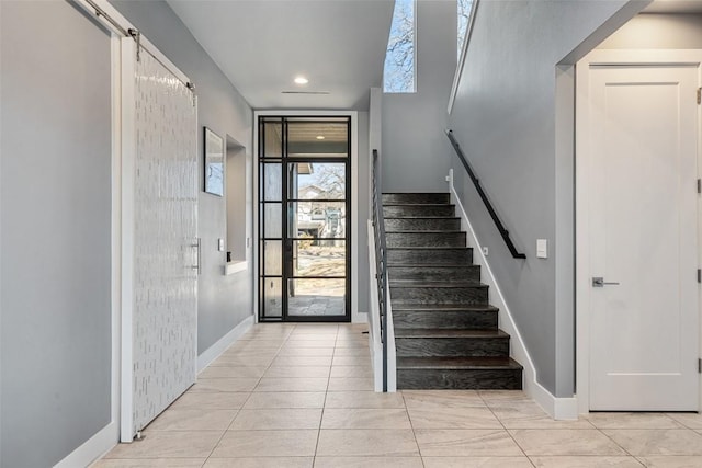 foyer featuring light tile patterned floors, stairway, and baseboards