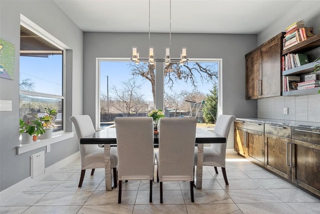 dining area with baseboards and a chandelier