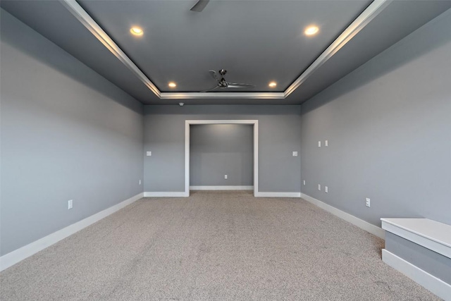 carpeted empty room featuring recessed lighting, baseboards, a tray ceiling, and ceiling fan