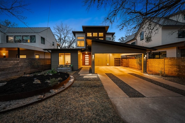 contemporary house featuring a carport, driveway, and fence