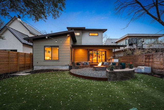 back of house with a patio, a fire pit, a fenced backyard, and a lawn