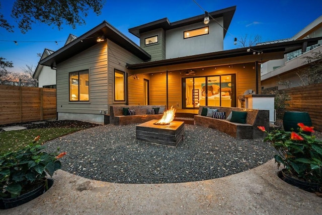 back of house with an outdoor living space with a fire pit, a patio, and fence