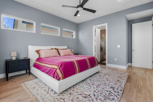 bedroom with visible vents, connected bathroom, baseboards, and wood finished floors