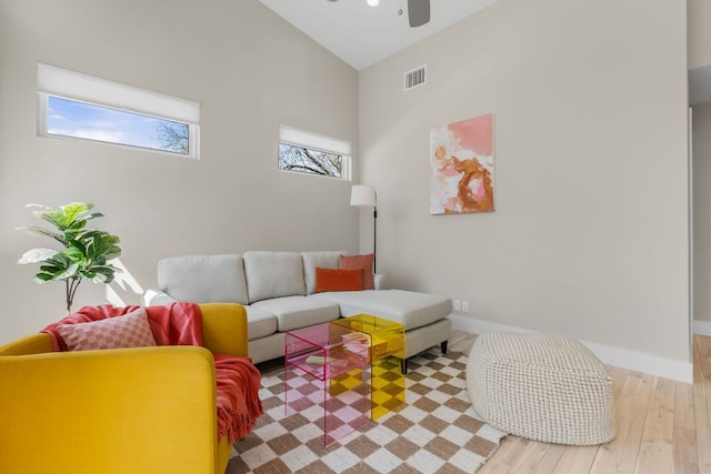 living area with visible vents, baseboards, ceiling fan, and wood finished floors