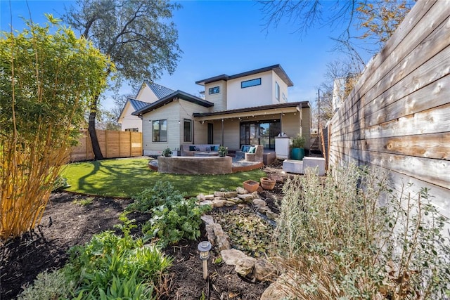 back of property with a patio area, a lawn, and a fenced backyard