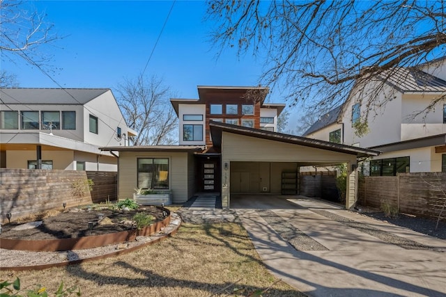 view of front of home featuring an attached carport, driveway, and fence