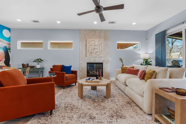 living room with visible vents, recessed lighting, a ceiling fan, and a premium fireplace