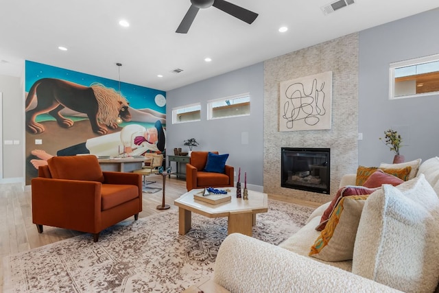 living room featuring visible vents, recessed lighting, a fireplace, wood finished floors, and a ceiling fan