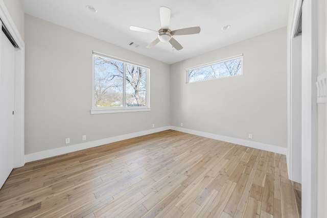 unfurnished bedroom with baseboards, visible vents, light wood-style flooring, ceiling fan, and a closet