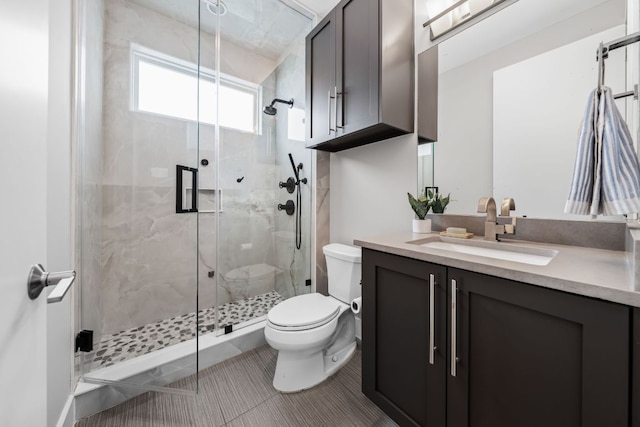 bathroom with tile patterned floors, vanity, toilet, and a shower stall