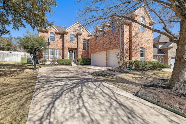 traditional-style home featuring a garage, brick siding, concrete driveway, and fence