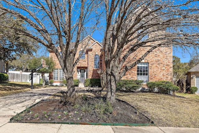 view of front of house featuring brick siding and fence