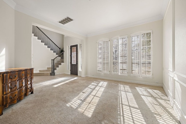 carpeted entryway featuring visible vents, plenty of natural light, ornamental molding, and stairs