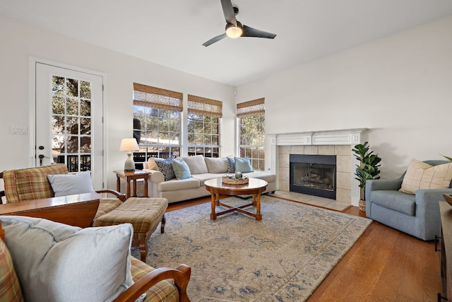 living room with a fireplace, wood finished floors, and a ceiling fan