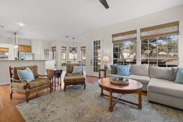 living area with baseboards, visible vents, recessed lighting, ceiling fan, and light wood-style floors