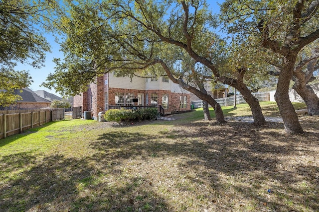 view of yard featuring a wooden deck, central AC unit, and a fenced backyard