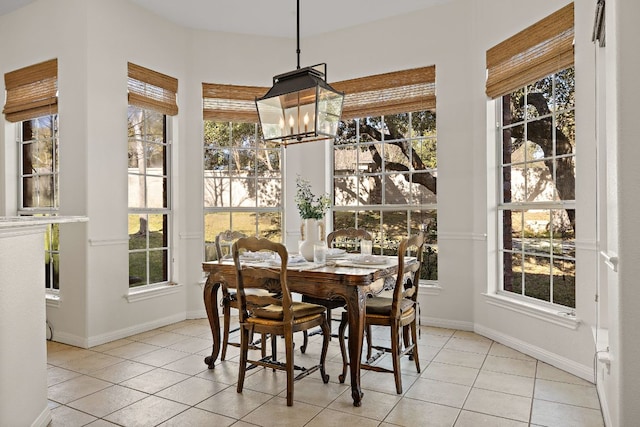 dining space featuring an inviting chandelier, light tile patterned floors, and a healthy amount of sunlight