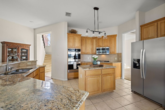 kitchen with a sink, a center island, stainless steel appliances, light tile patterned flooring, and decorative backsplash