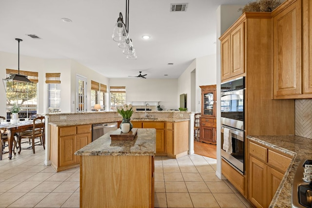 kitchen featuring light tile patterned floors, visible vents, appliances with stainless steel finishes, and a kitchen island